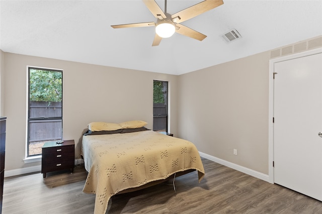 bedroom with hardwood / wood-style floors, multiple windows, and ceiling fan