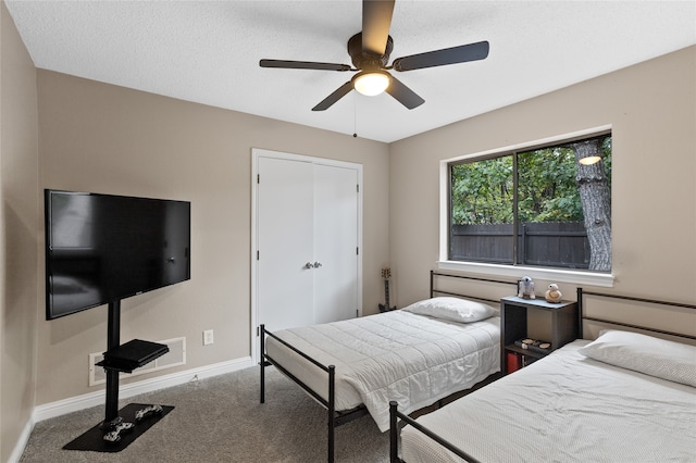 carpeted bedroom featuring ceiling fan, a textured ceiling, and a closet