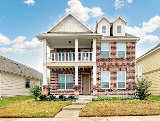 view of front facade featuring a balcony and a front yard