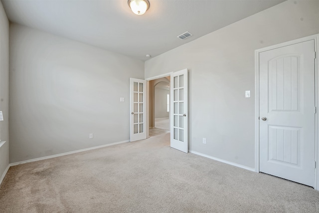 carpeted spare room with french doors