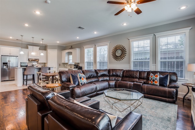 living room featuring ceiling fan, plenty of natural light, and ornamental molding