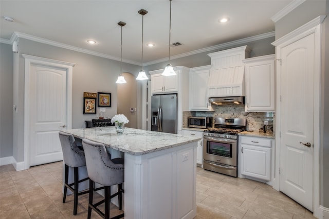 kitchen with hanging light fixtures, white cabinets, decorative backsplash, and appliances with stainless steel finishes