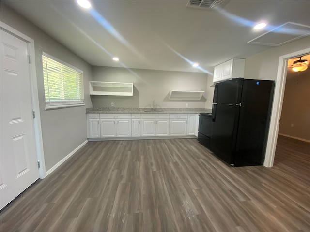 kitchen featuring dark wood-type flooring, light stone counters, sink, white cabinetry, and fridge