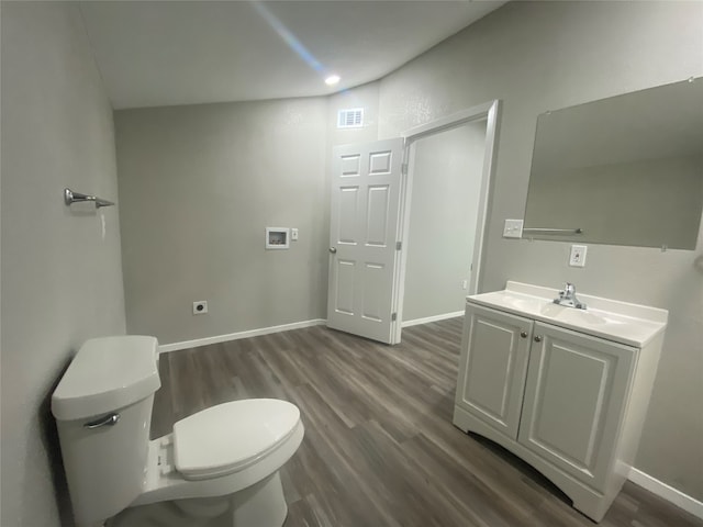 full bathroom featuring shower / bath combination, lofted ceiling, toilet, hardwood / wood-style flooring, and vanity