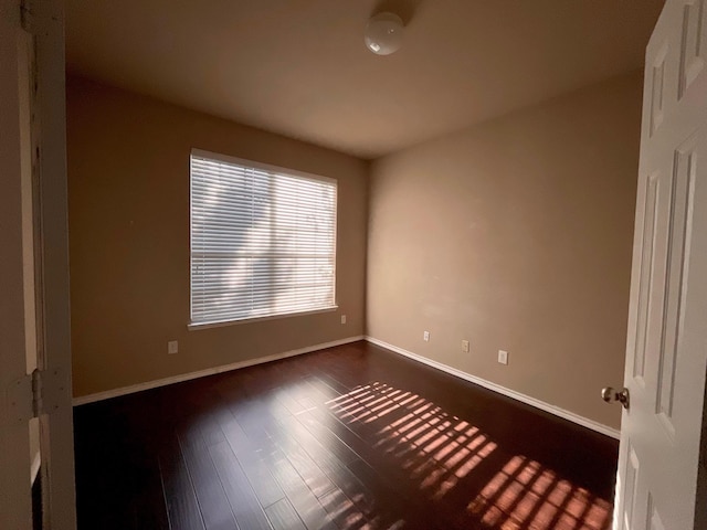 unfurnished room with dark wood-type flooring