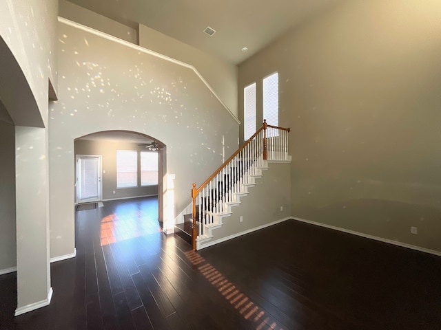 entrance foyer featuring a high ceiling, dark hardwood / wood-style floors, and ceiling fan