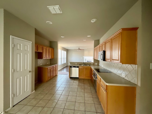 kitchen featuring kitchen peninsula, tasteful backsplash, stainless steel appliances, ceiling fan, and light tile patterned flooring