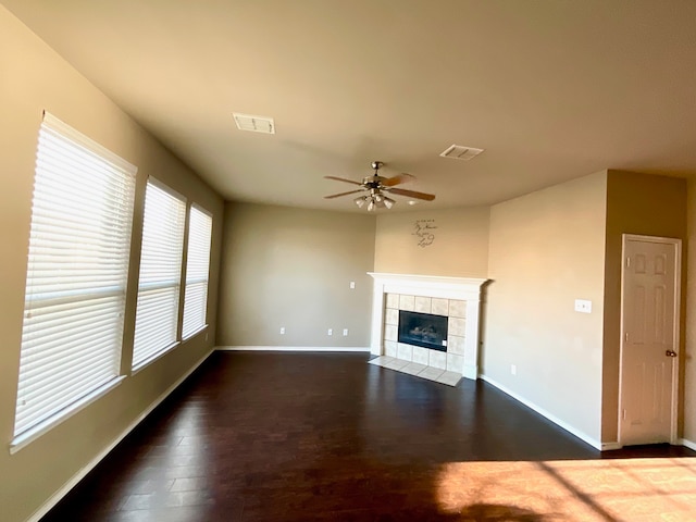 unfurnished living room featuring a fireplace, dark hardwood / wood-style flooring, and ceiling fan