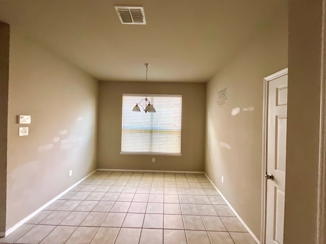 unfurnished dining area featuring light tile patterned floors and an inviting chandelier