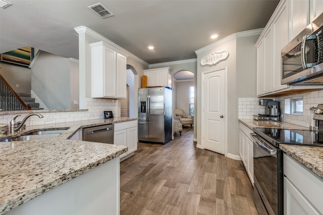 kitchen featuring tasteful backsplash, appliances with stainless steel finishes, dark hardwood / wood-style floors, sink, and white cabinets