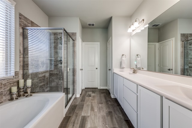 bathroom featuring vanity, hardwood / wood-style floors, and separate shower and tub