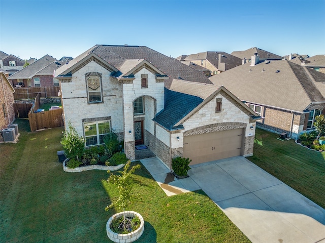 french provincial home featuring a garage, central AC, and a front yard