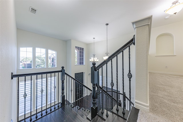 stairway featuring a chandelier and carpet