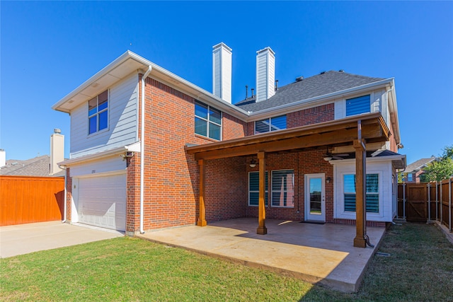 back of house with a garage, a yard, and a patio area