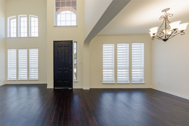 entryway featuring a high ceiling, dark hardwood / wood-style floors, and an inviting chandelier