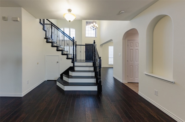 entryway with hardwood / wood-style floors and an inviting chandelier