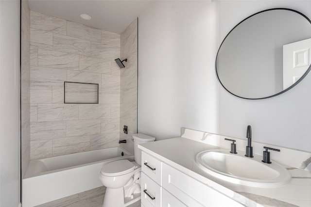 full bathroom featuring vanity, tiled shower / bath, and toilet