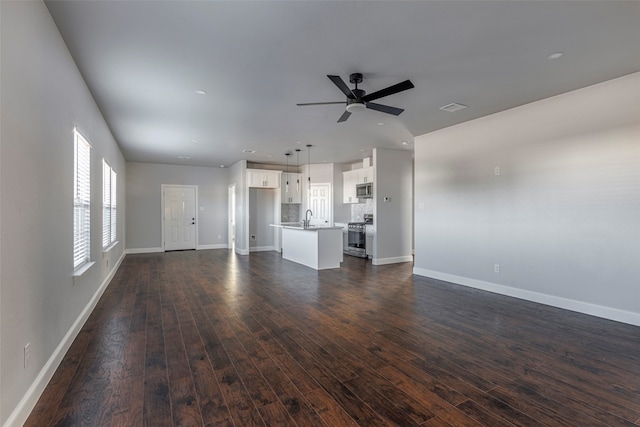 unfurnished living room with dark hardwood / wood-style flooring, sink, and ceiling fan