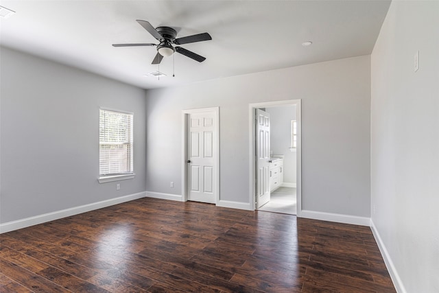 unfurnished bedroom featuring ceiling fan, dark hardwood / wood-style floors, and connected bathroom