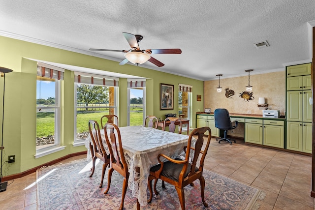 dining space with a textured ceiling, built in desk, light tile patterned floors, and crown molding