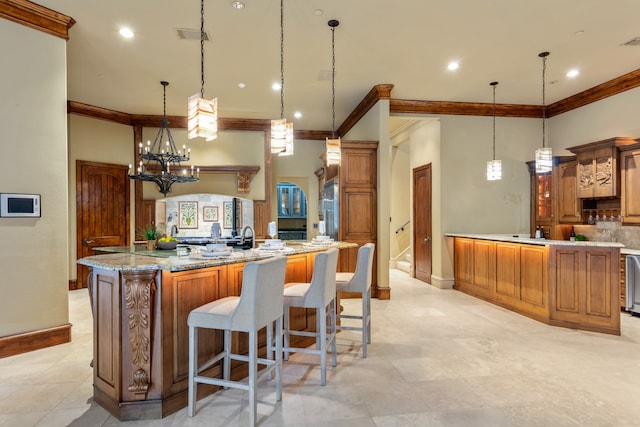 kitchen featuring a large island, decorative light fixtures, ornamental molding, and backsplash