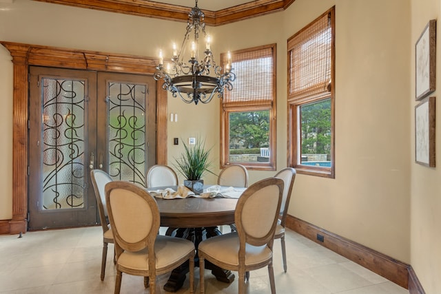 dining room featuring crown molding, french doors, and an inviting chandelier