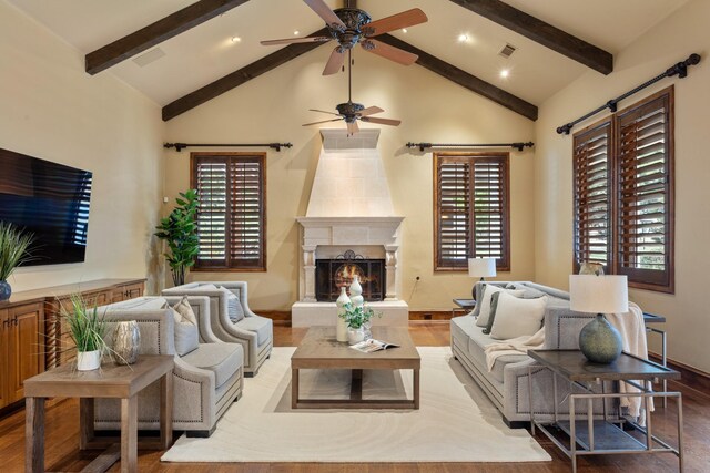 living room with hardwood / wood-style flooring, ceiling fan, beamed ceiling, and high vaulted ceiling