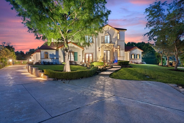 mediterranean / spanish house featuring a yard and french doors