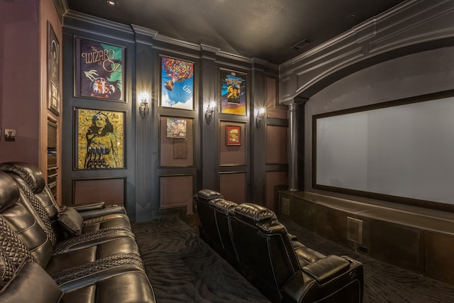 cinema room with carpet, ornate columns, and ornamental molding