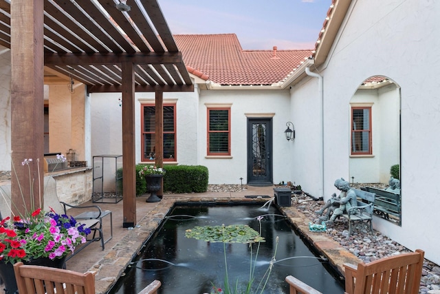 patio terrace at dusk featuring exterior kitchen and a pergola