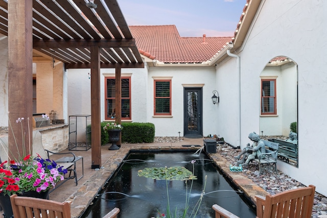 patio terrace at dusk with pool water feature, area for grilling, and a pergola