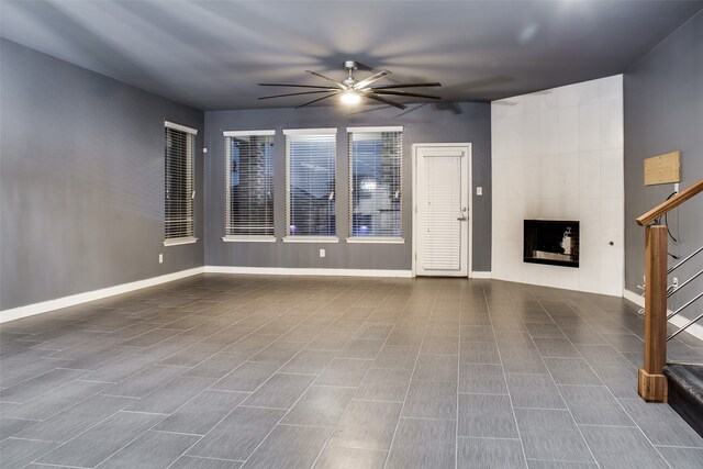 unfurnished living room featuring a fireplace and ceiling fan