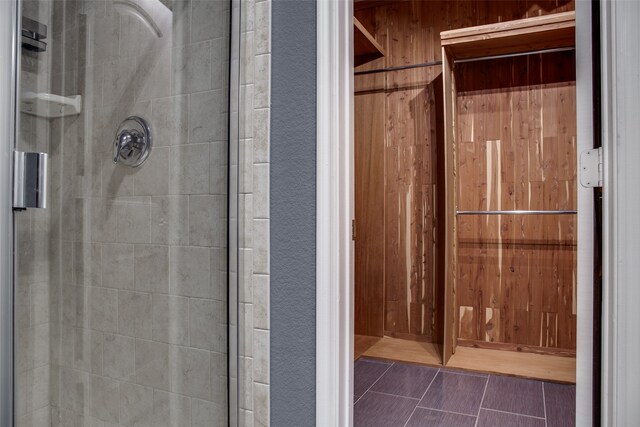 bathroom featuring walk in shower and wood walls