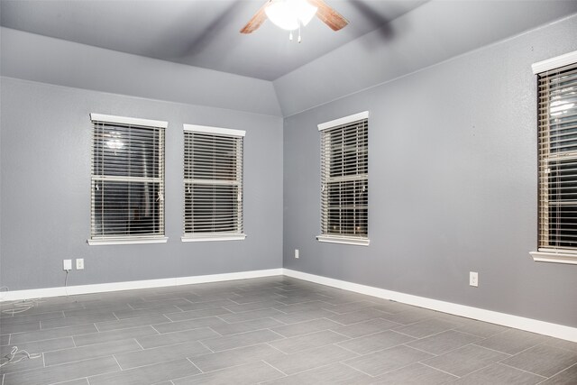 empty room with vaulted ceiling, hardwood / wood-style flooring, and ceiling fan