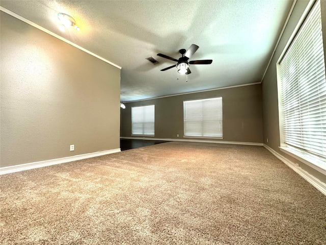 spare room with a textured ceiling, ceiling fan, carpet, and ornamental molding