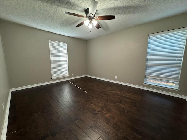 spare room featuring ceiling fan, plenty of natural light, a textured ceiling, and dark hardwood / wood-style floors