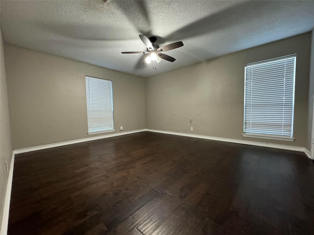 empty room with ceiling fan, dark hardwood / wood-style flooring, and a textured ceiling