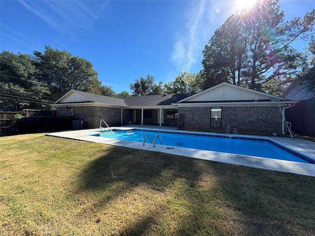 view of pool featuring a yard, a patio, and central AC unit