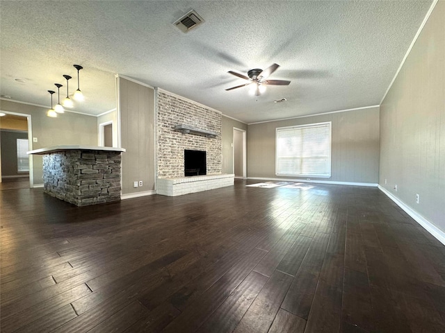 unfurnished living room with a fireplace, ornamental molding, and dark hardwood / wood-style flooring