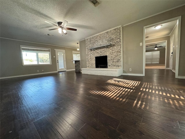 unfurnished living room with ornamental molding, dark hardwood / wood-style flooring, and a brick fireplace