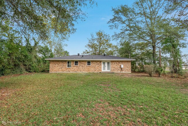 rear view of property with a yard