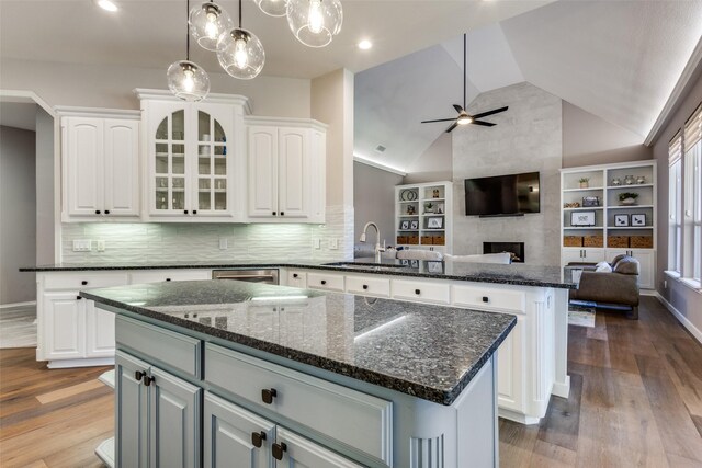 kitchen with tasteful backsplash, white cabinets, a fireplace, and a kitchen island