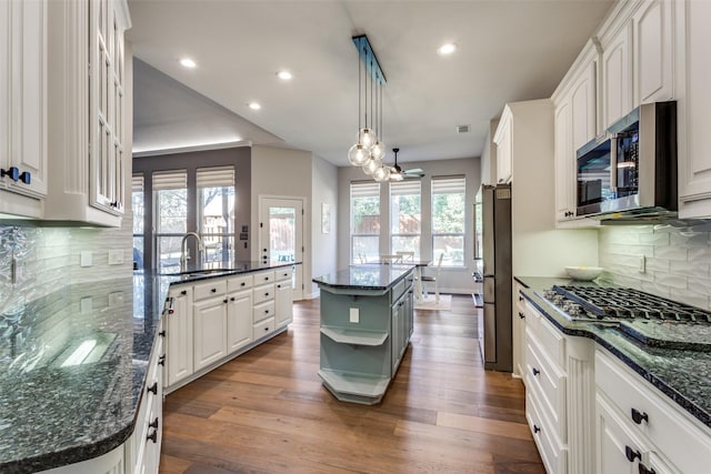 kitchen featuring sink, a kitchen island, pendant lighting, white cabinets, and appliances with stainless steel finishes