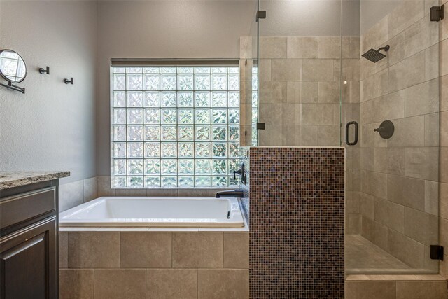 bathroom with vanity and shower with separate bathtub