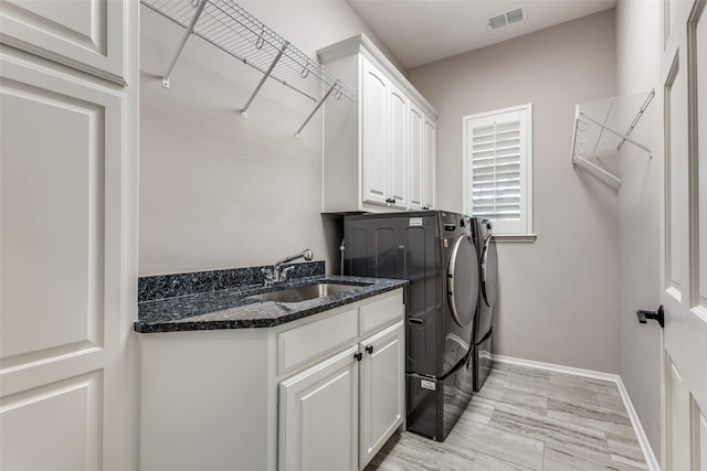 laundry room with washer and dryer, cabinets, and sink