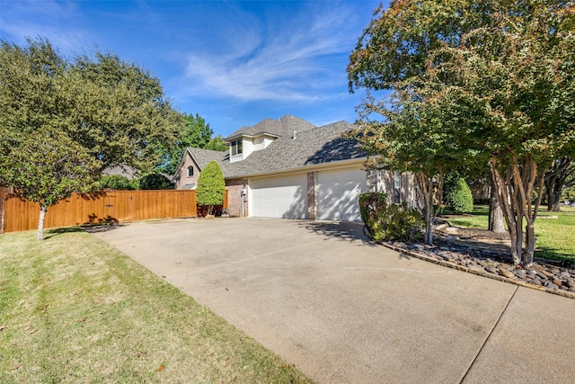 view of side of home featuring a garage and a lawn