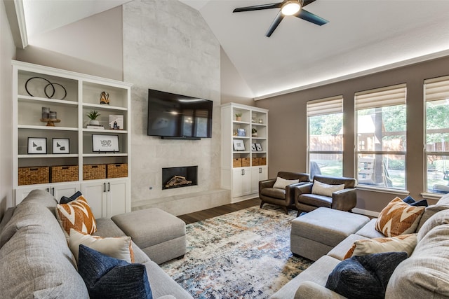 living room with ceiling fan, dark wood-type flooring, a high end fireplace, and vaulted ceiling