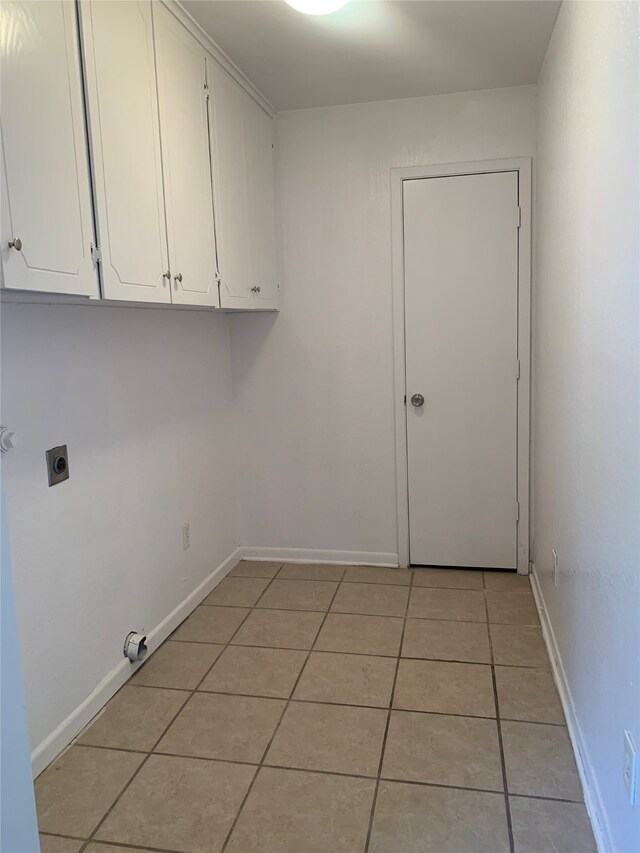 laundry room with light tile patterned floors, cabinets, and hookup for an electric dryer