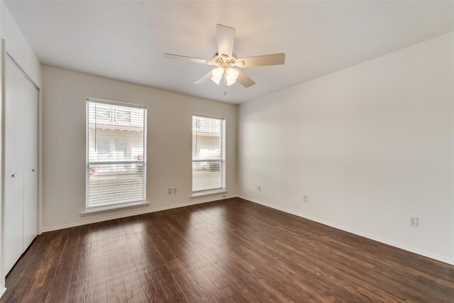 spare room with dark hardwood / wood-style floors and ceiling fan