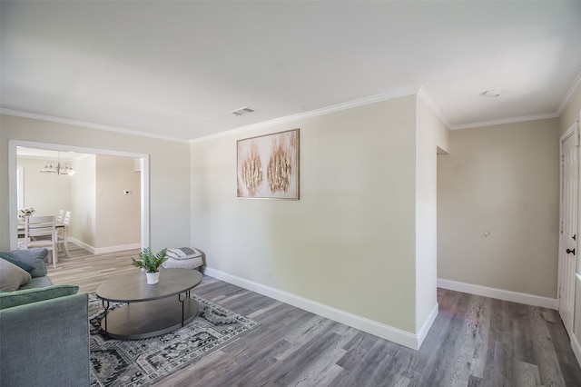 living room featuring hardwood / wood-style flooring, crown molding, and a chandelier